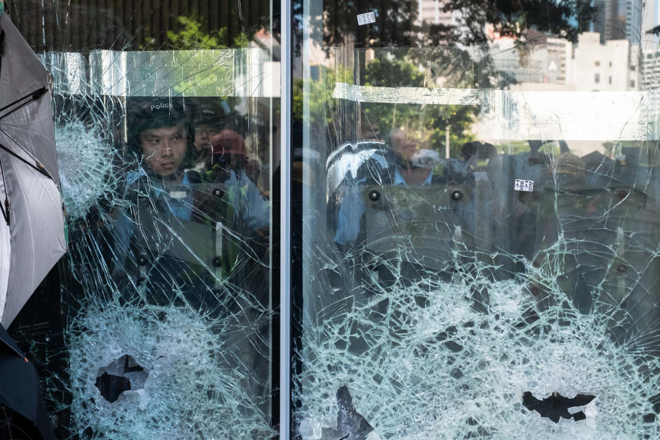 HONG KONG - JULY 01: Protesters smash glass doors and windows of the Legislative Council Complex protest against the extradition bill on July 01, 2019 in Hong Kong, China. Thousands of pro-democracy protesters faced off with riot police on Monday during the 22nd anniversary of Hong Kong's return to Chinese rule as riot police officers used batons and pepper spray to push back demonstrators. The city's embattled leader Carrie Lam watched a flag-raising ceremony on a video display from inside a convention centre, citing bad weather, as water-filled barricades were set up around the exhibition centre.(Photo by Billy H.C. Kwok/Getty Images)