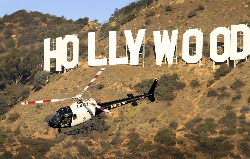 Seib, Al –– B581835589Z.1 HOLLYWOOD, CA – AUGUST 18, 2011: A LAPD helicopter searches a steep Brush Canyon off Canyon Drive in Griffith Park Wednesday as Los Angeles Police Detectives are investigating the slaying of a man believed to be of Armenian descent whose head was discovered Tuesday afternoon by two dogs off a hiking trail below the Hollywood sign. (Al Seib / Los Angeles Times)