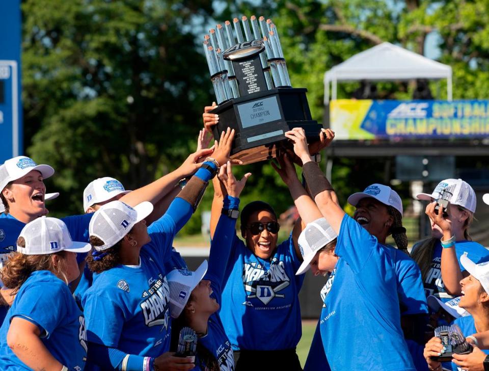 Duke head coach Marissa Young, center, hoists the ACC Tournament trophy following the Blue Devils’ 6-3 win over Florida State on Saturday, May 11, 2024, in Durham, N.C.