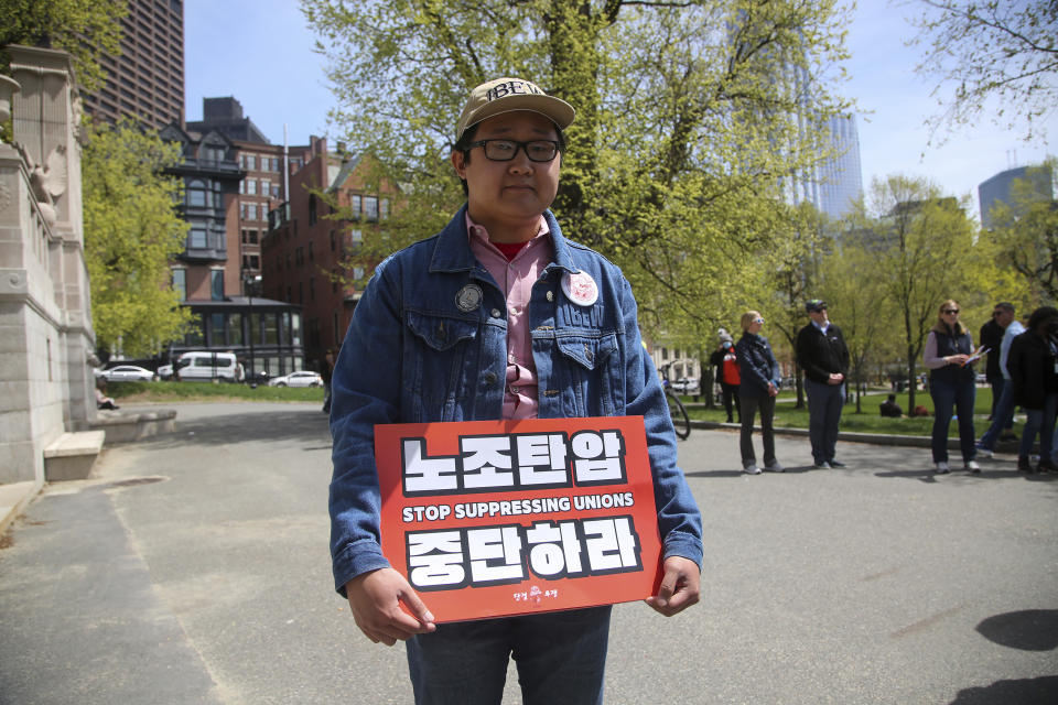 Public sector worker Hong Doo-jung, 25 years old of Worcester, holds a sign during the visit of South Korea's President Yoon Suk Yeol to the Massachusetts State House, Friday, April 28, 2023, in Boston, Mass. Yoon stopped at the State House ahead of a talk at Harvard University as he wrapped up a state visit to the United States. (AP Photo/Reba Saldanha)