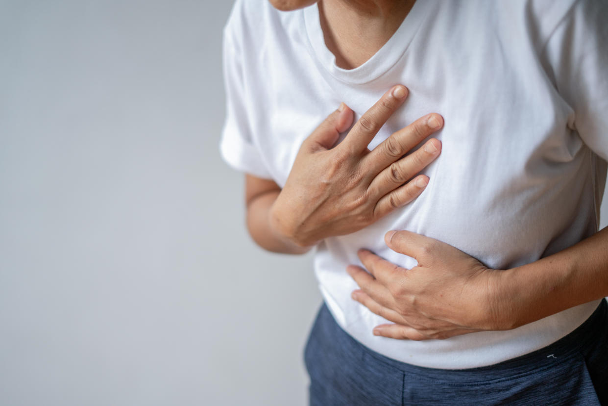 Woman suffering from chest pain. Hand on heart.