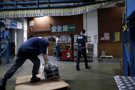 An employee operates a forklift to transport a pallet stacked with bundles of the Apple Daily newspaper, published by Next Media, at the company's printing facility in Hong Kong, China November 26, 2015. REUTERS/Tyrone Siu