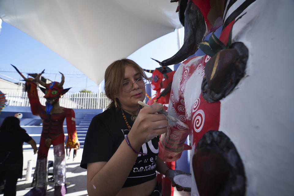 Artisan Paula Villalobos paints her "Judas" creation that she has crafted for the upcoming "Burning of Judas," celebration, at the Santa Maria La Ribera Cultural Center, in Mexico City, Wednesday, April 5, 2023. During this popular activity on the sidelines of the Holy Week celebrations of the Catholic Church, people gather in neighborhoods on Holy Saturday across the country to burn cardboard symbolic embodiments of evil. (AP Photo/Marco Ugarte)