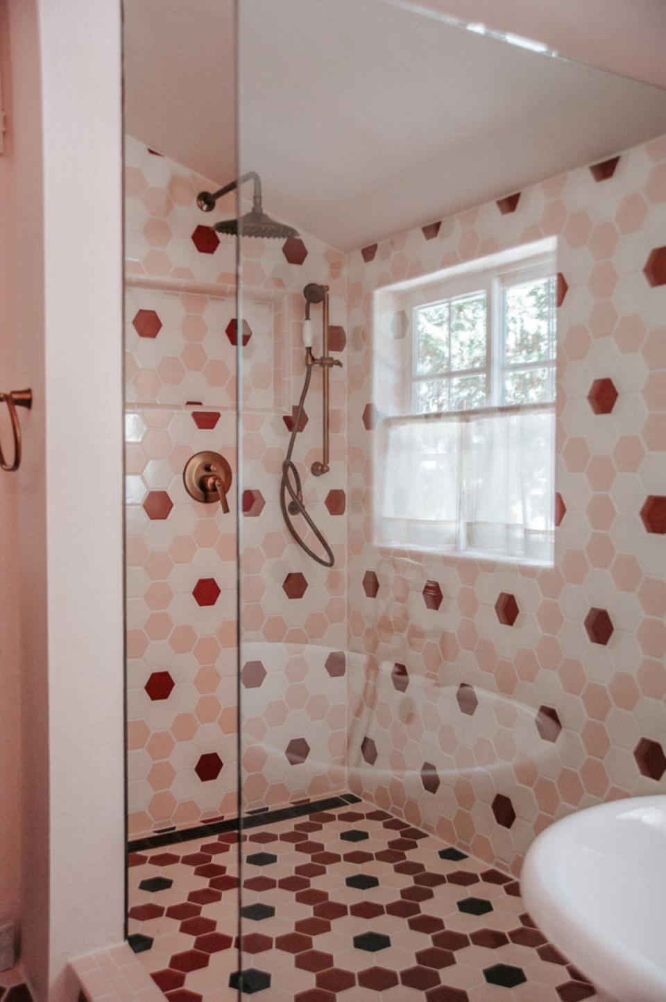 Pink hexagon tiles in bathroom in a floral pattern on floor and walls