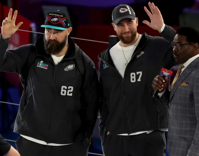 PHOENIX, ARIZONA – FEBRUARY 06: (L-R) Brothers Jason Kelce #62 of the Philadelphia Eagles and Travis Kelce #87 of the Kansas City Chiefs wave onstage during Super Bowl LVII Opening Night presented by Fast Twitch at Footprint Center on February 06, 2023 in Phoenix, Arizona. <em>Photo by Christian Petersen/Getty Images.</em>