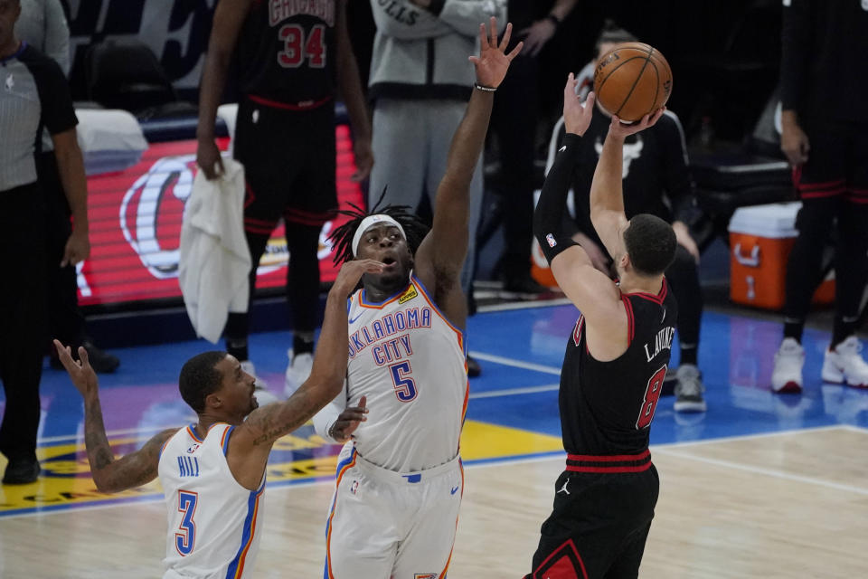 Chicago Bulls guard Zach LaVine (8) attempts a 3-point shot over Oklahoma City Thunder guard George Hill (3) and forward Luguentz Dort (5), but misses in the closing seconds of overtime of an NBA basketball game Friday, Jan. 15, 2021, in Oklahoma City. (AP Photo/Sue Ogrocki)