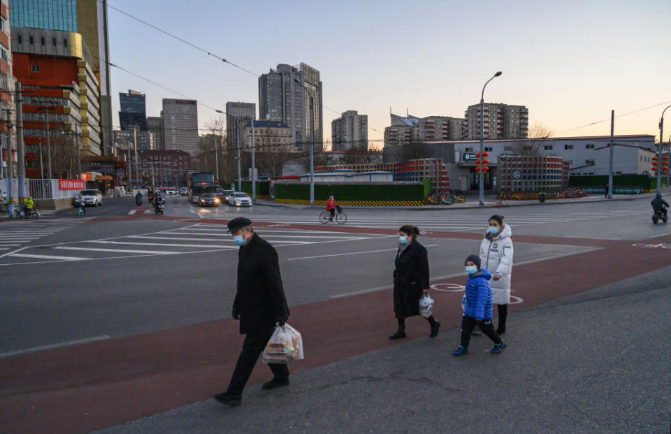 BEIJING, CHINA - MARCH 04: A family wear protective masks as they cross an intersection on March 4, 2020 in Beijing, China. The number of cases of the deadly new coronavirus COVID-19 being treated in China dropped to below 28,000 in mainland China Wednesday, in what the World Health Organization (WHO) declared a global public health emergency last month. China continued to lock down the city of Wuhan, the epicentre of the virus, in an effort to contain the spread of the pneumonia-like disease. Officials in Beijing have put in place a mandatory 14 day quarantine for all people returning to the capital from other places in China. The number of those who have died from the virus in China climbed to over 2984 on  Thursday, mostly in Hubei province, and cases have been reported in other countries including the United States, Canada, Australia, Japan, South Korea, India, Iran, Italy, the United Kingdom, Germany, France and several others. The World Health Organization has warned all governments to be âon alertâ and raised concerns over a possible pandemic. Some countries, including the United States, have put restrictions on Chinese travellers entering and advised their citizens against travel to China.(Photo by Kevin Frayer/Getty Images)