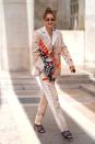<p>In an artfully patterned pantsuit, layered necklaces, and quilted charcoal gray heels.</p>