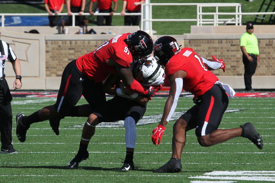 Texas Tech defensive lineman Nelson Mbanasor, left, takes down Oklahoma State quarterback Spencer Sanders during the Red Raiders' 45-35 victory in 2019. Mbanasor, who spent five seasons in the Tech program, has had his name entered into the NCAA transfer portal. He has one year of eligibility remaining.