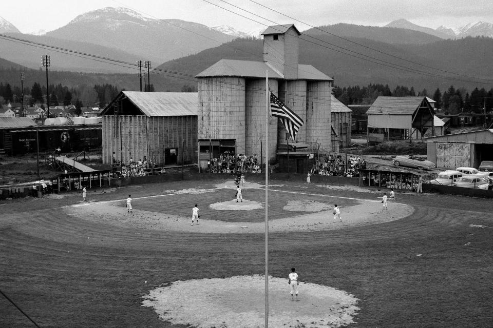 This photo from the 1960s shows a baseball field next to a railyard in Libby, Mont., where asbestos-tainted vermiculite was stored after being mined from a nearby mountain. Thousands of people have been diagnosed with asbestos-related illnesses from exposure in the Libby area. A trial starts Monday in a lawsuit against BNSF Railway from the estates of two people who used to live in Libby and died from mesothelioma, a rare lung cancer caused by asbestos exposure. (The Western News via AP)
