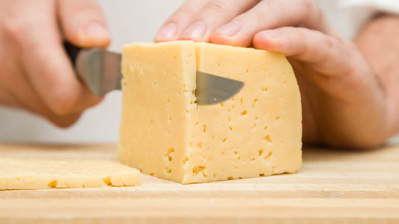Hands slicing cheese