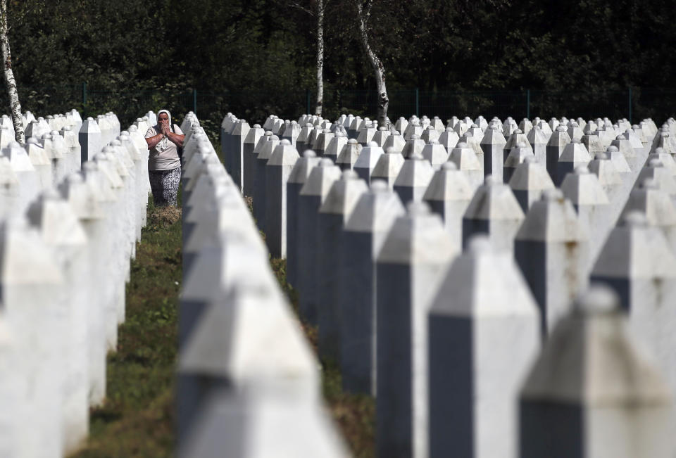 A Bosnian Muslim woman reacts as she walks among gravestones at the memorial centre of Potocari near Srebrenica, 150 kms north east of Sarajevo, Bosnia, Tuesday, Aug. 14, 2018. The leader of Bosnia's Serbs has downplayed the massacre of some 8,000 Bosnian Muslims in Srebrenica during the war in 1995 and called for the reopening of an investigation into the worst carnage in Europe since World War II. (AP Photo/Darko Vojinovic)