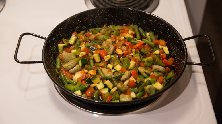 vegetable cooking in paella pan 