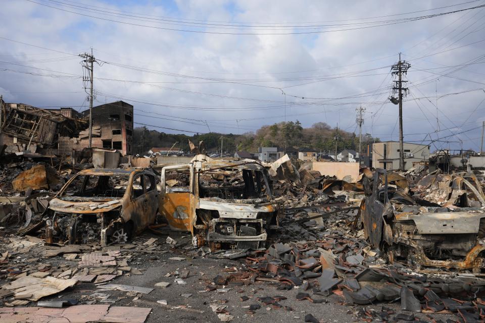 Burned-out vehicles and other debris are seen after a fire at a shopping area in Wajima in the Noto peninsula, facing the Sea of Japan, northwest of Tokyo, Friday, Jan. 5, 2024, following Monday's deadly earthquake. (AP Photo/Hiro Komae)