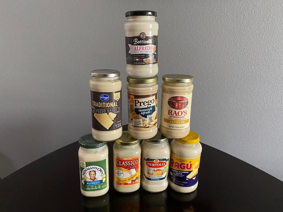 Several jars of Alfredo sauce arranged in a pyramid shape