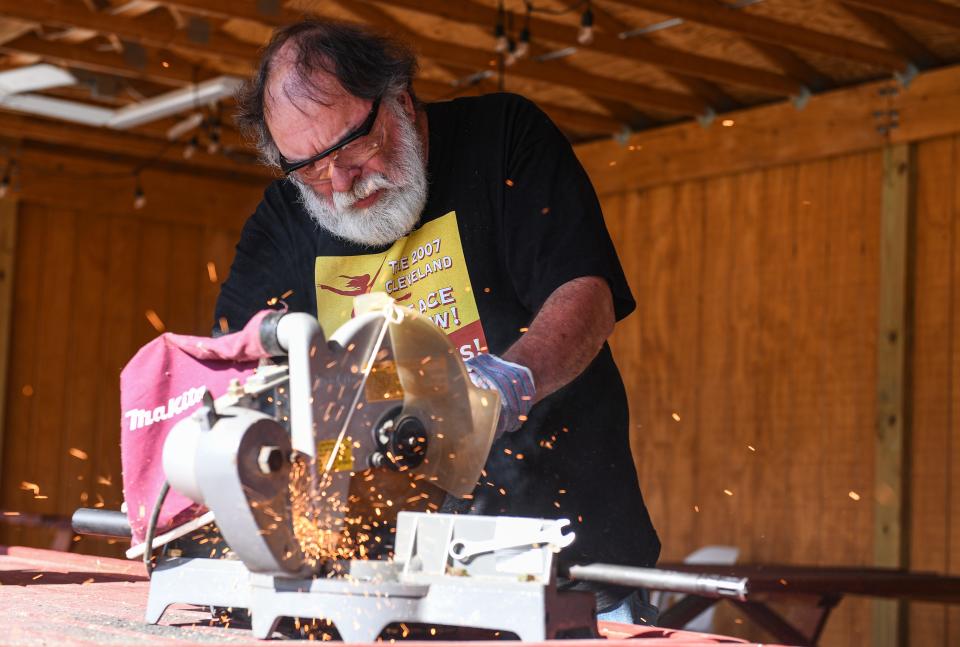 Steve Rithcey saws apart guns to be used as raw material for gardening tools during the Festival of Nonviolence & Peacemaking, Thursday, July 18, 2024, in Akron, Ohio.