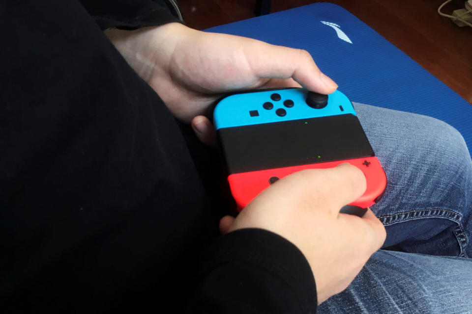 Chinese tutor Zhao plays a game on Nintendo Switch at his apartment in Beijing, China April 24, 2020. Picture taken April 24, 2020. REUTERS/Martin Pollard