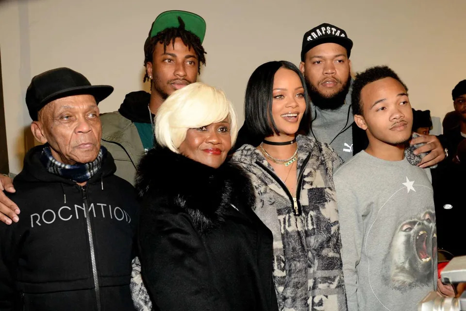 <p>Kevin Mazur/Getty</p> Rihanna with family and friends in 2016