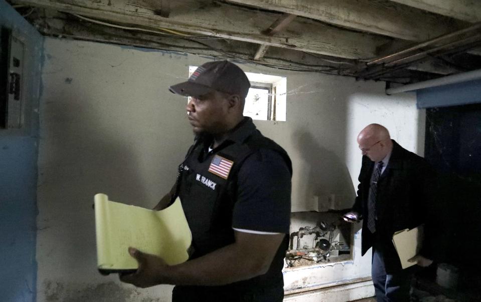 Rockland County Fire Inspector Willer Franck and Director of the Office of Buildings and Codes, Ed Markunas inspect a house next to a two-family house where there was a fatal fire on Lake St. in Spring Valley March 6, 2023.