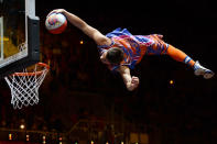 An artist scores a basket during a show held prior the women's preliminary round group A basketball match of the London 2012 Olympic Games Angola vs. Croatia on August 3, 2012 at the basketball arena in London. AFP PHOTO / TIMOTHY A. CLARY