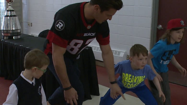 Young fans tackle Ottawa Redblacks players in Corner Brook