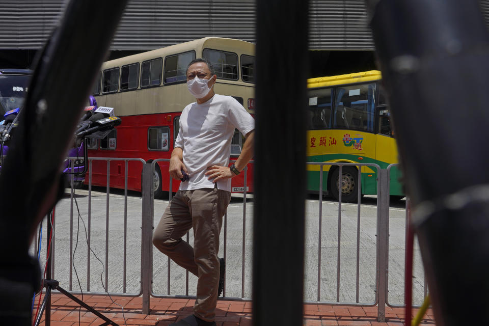 Occupy Central leader Benny Tai stands in front of a vintage double-deck bus used as a polling center for an unofficial "primary" for pro-democracy candidates ahead of legislative elections in Hong Kong Saturday, July 11, 2020. Tai, a professor and leading figure in Hong Kong's political opposition has been fired from his university job following China's passage of a sweeping new national security law. (AP Photo/Vincent Yu)