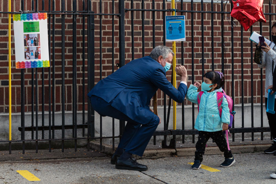 El alcalde Bill de Blasio saluda a un alumno que llega para el primer día de clases presenciales en el barrio Elmhurst de Queens, el 21 de septiembre de 2020. (Todd Heisler/The New York Times).