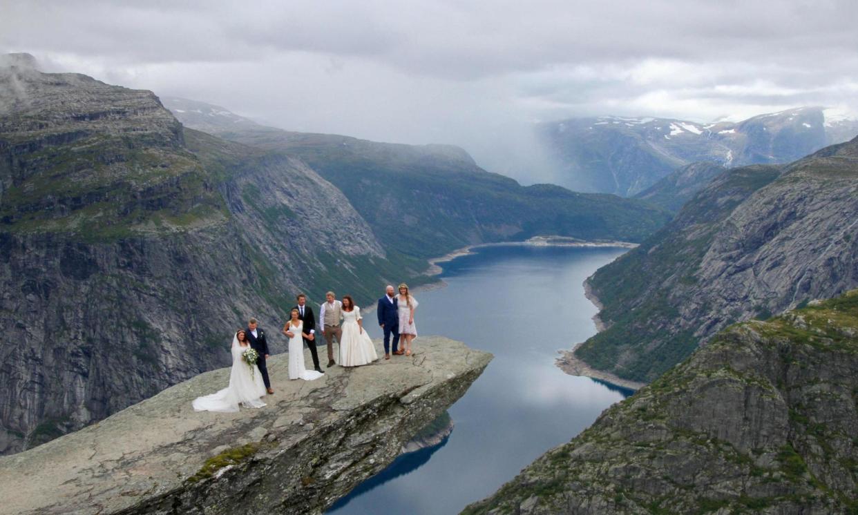 <span>Bridal couples pose on Trolltunga rock formation in Ullensvang Municipality, Vestland county, Norway.</span><span>Photograph: Ase Marie Evjen/Trolltunga AS/NTB/AFP/Getty Images</span>