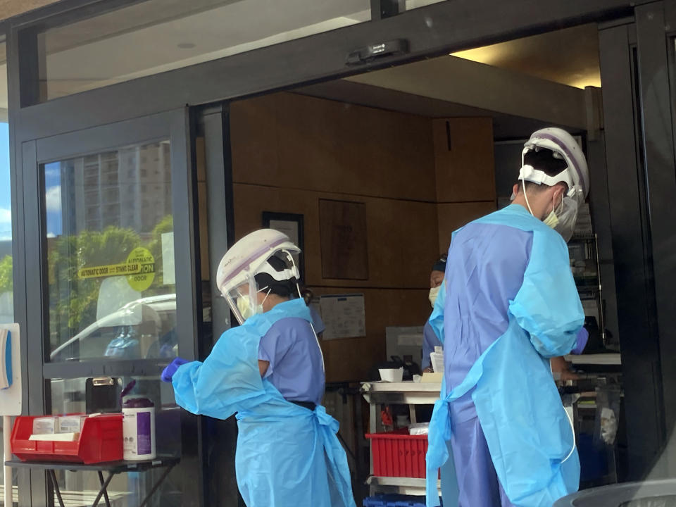 Hospital workers process COVID-19 tests at a hospital in Aiea, Hawaii, Wednesday, Sept. 15, 2021. Hawaii officials are facing pressure to increase COVID-19 testing for travelers. The islands are weathering a record surge and federal guidelines are being changed to require negative virus tests from both vaccinated and unvaccinated travelers to the U.S. State leaders have resisted implementation of a two-test policy for arriving travelers despite evidence that more COVID-19 testing would help reduce the spread of disease, especially in an isolated destination location like Hawaii. (AP Photo/Caleb Jones)