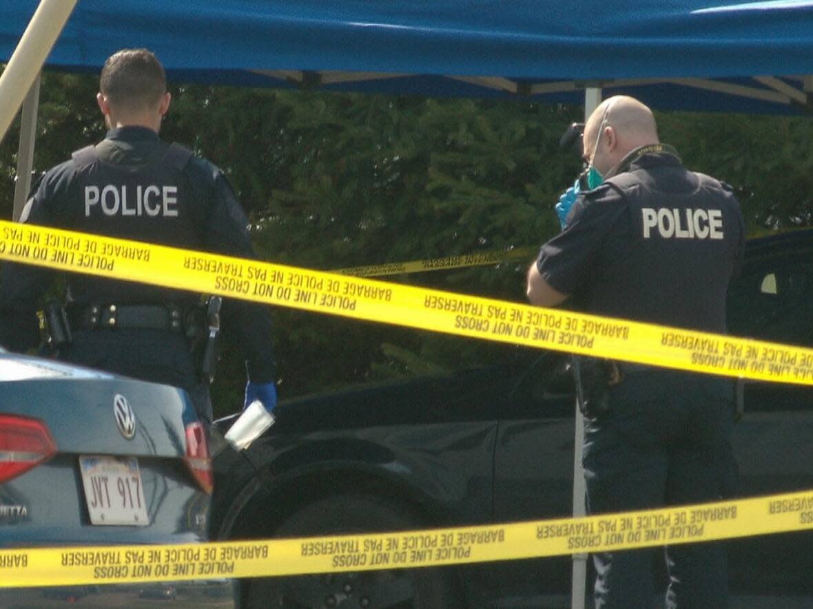 An RCMP member photographs the scene outside a Logan Lane duplex in Moncton's north end after 18-year-old Joedin Leger was fatally shot on April 25, 2022. (Pierre Fournier/CBC - image credit)