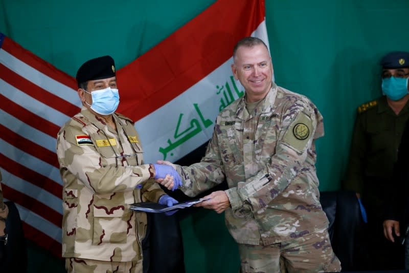 U.S. Brigadier General Vincent Barker shakes hands with Iraqi General Mohammed Fadel during the hand over of US-led coalition forces to Iraqi Security Forces at Qayyarah Airfield West in the south of Mosul