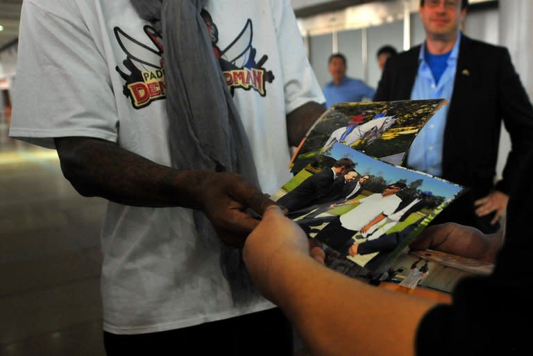 Dennis Rodman shows pictures of him reportedly with North Korea's Kim Jong-Un to the media at the Beijing airport on September 7, 2013. He showed a waiting crowd of reporters dozens of pictures, some of them of him with Kim, who Rodman describes as his "friend"