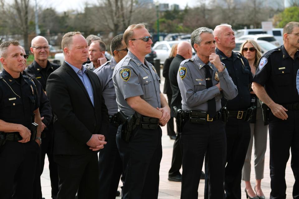 Law enforcement officers gather to watch a No 820 campaign event on the south plaza of the state Capitol on Monday.