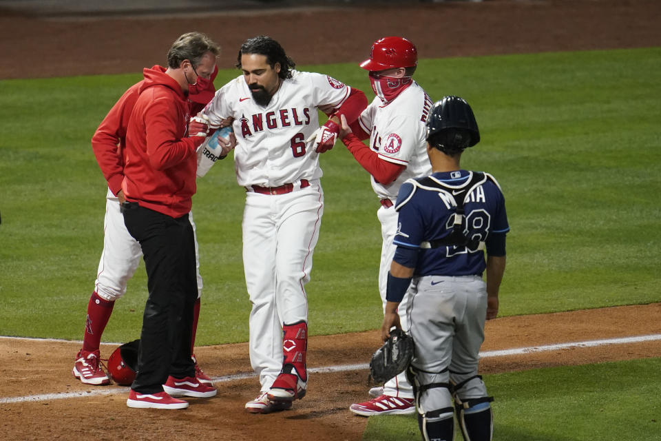 Los Angeles Angels' Anthony Rendon (6) is helped up after hitting a foul ball off his leg during the eighth inning of a baseball game against the Tampa Bay Rays Monday, May 3, 2021, in Anaheim, Calif. (AP Photo/Marcio Jose Sanchez)