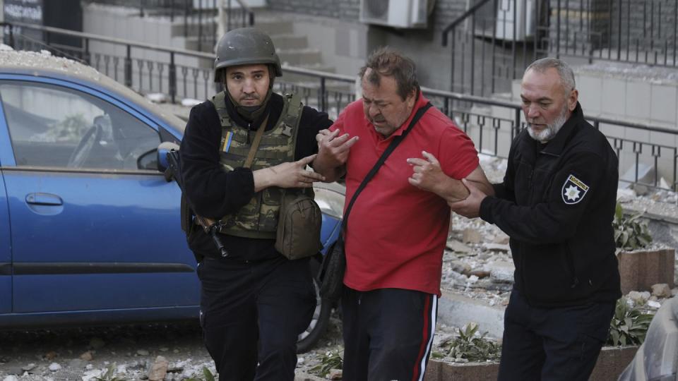 Police officers help an injured man evacuate from a multi-story apartment building to an ambulance during a  wave of bombardments targeting in Kyiv, Ukraine, Tuesday, May 30, 2023. (AP Photo/Alex Babenko)