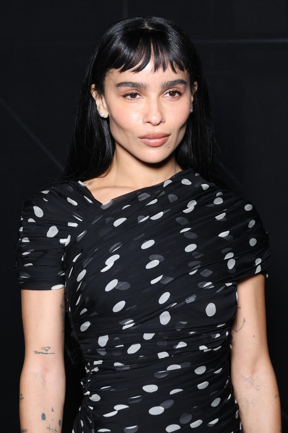 Zoe Kravitz sports piecey, micro-length bangs with long layers at the Saint Laurent womenswear spring-summer 2024 fashion show on September 2023.