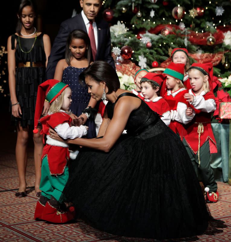 FILE PHOTO: U.S. first lady Michelle Obama greets a child dressed as an elf at the Christmas in Washington Celebration