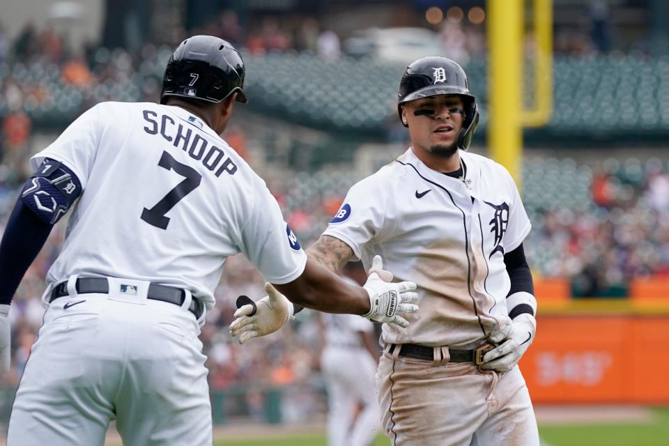 Tigers' Jonathan Schoop (7) greets teammate Javier Baez after Baez scored during the fifth inning against the Cleveland Guardians, Wednesday, July 6, 2022, in Detroit.