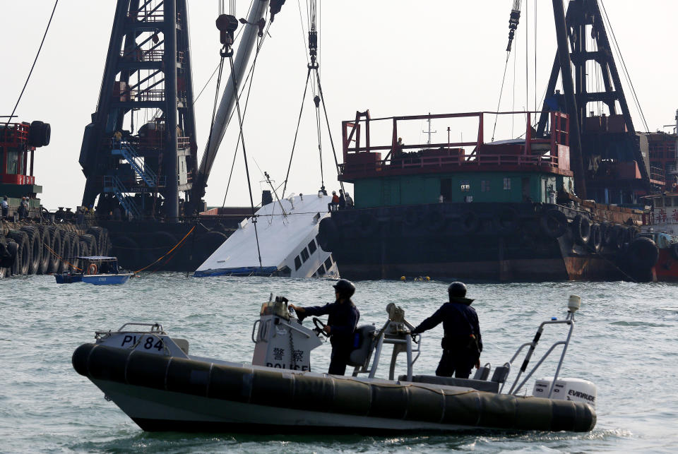 Police officers on a small boat secure the area around a half submerged boat Tuesday Oct. 2, 2012 after Monday night's collision near Lamma Island, off the southwestern coast of Hong Kong Island. The boat packed with revelers on a long holiday weekend collided with a ferry and sank, killing at least 36 people and injuring dozens, authorities said. (AP Photo/Vincent Yu)