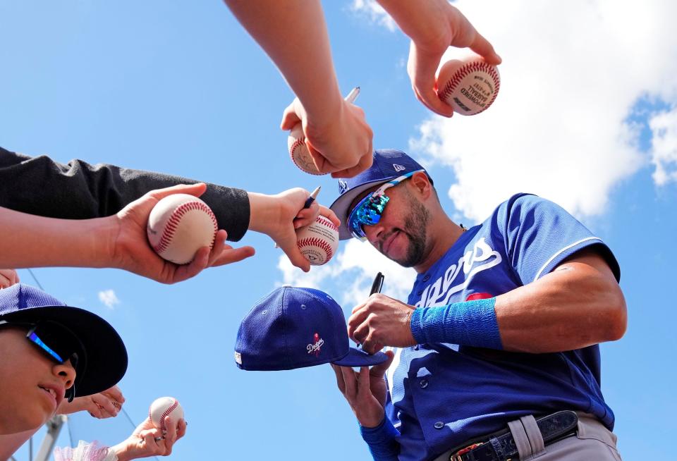 Los Angeles Dodgers left fielder David Peralta signs autographs before his team's spring training game against the Arizona Diamondbacks at Salt River Fields on March 23, 2023.