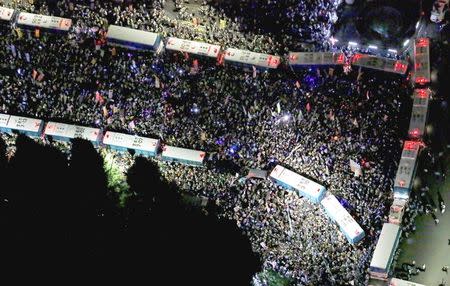 An aerial view shows protesters gathering at a rally against Japan's Prime Minister Shinzo Abe's security bill and his administration, as police use parked buses to block protesters in front of the parliament building in Tokyo, in this photo taken by Kyodo September 14, 2015. Mandatory credit REUTERS/Kyodo