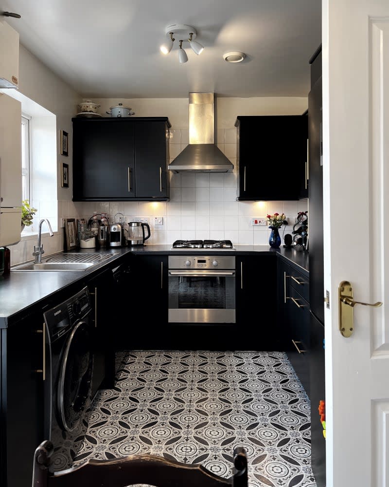 White kitchen with black cabinets and black and white floor after remodel