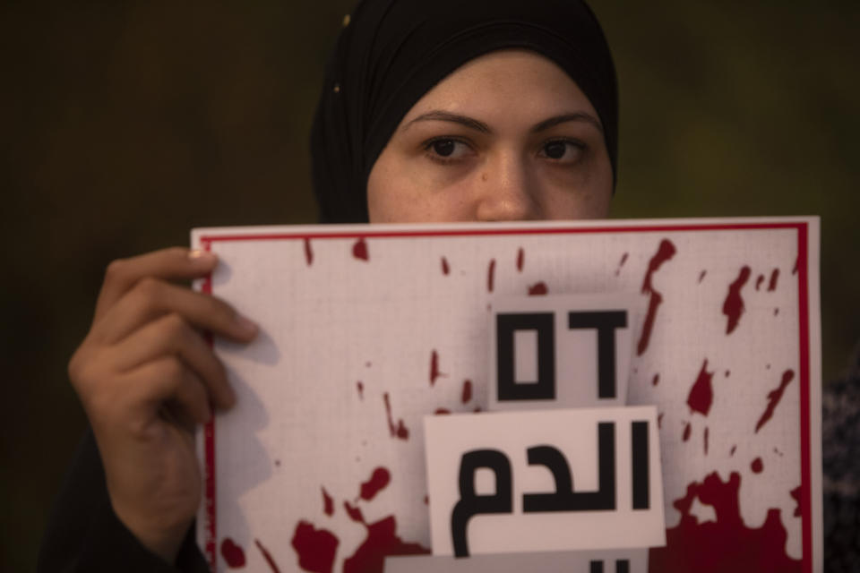 Protesters hold signs and chant slogans during a demonstration against violence near the house of Public Security Minister Omer Barlev in the central Israeli town of Kokhav Ya'ir, Saturday, Sept. 25, 2021. Arab citizens of Israel are seeking to raise awareness about the spiraling rate of violent crime in their communities under the hashtag "Arab lives matter," but unlike a similar campaign in the United States, they are calling for more policing, not less. Sign reads: "Blood"(AP Photo/Sebastian Scheiner)