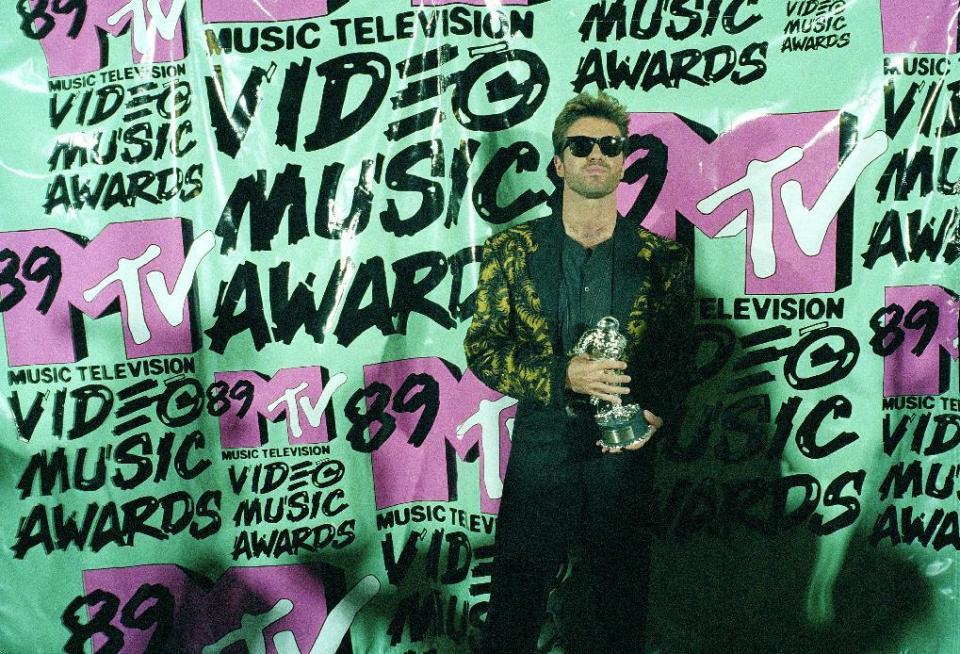 FILE - In this Wednesday, Sept. 6, 1989 file photo, musician George Michael holds his trophy after winning the 1989 Video "Vanguard Award" for his "Father Figure" video during the MTV Music Awards at the Universal Ampitheatre in Universal City, Calf. Michael, who rocketed to stardom with WHAM! and went on to enjoy a long and celebrated solo career lined with controversies, has died, his publicist said Sunday, Dec. 25, 2016. He was 53. (AP Photo/Alan Greth)