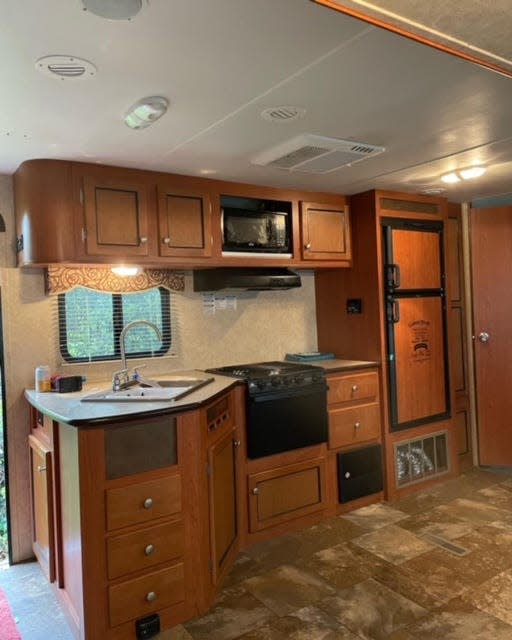 BEFORE: The kitchen cabinets were painted white, new hardware was added and the countertops were freshened up with contact paper.