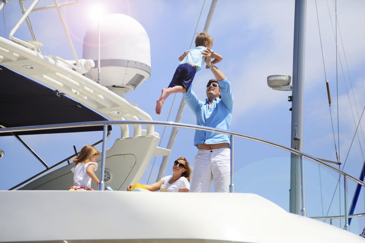 young wealthy family enjoying summer vacation on yacht