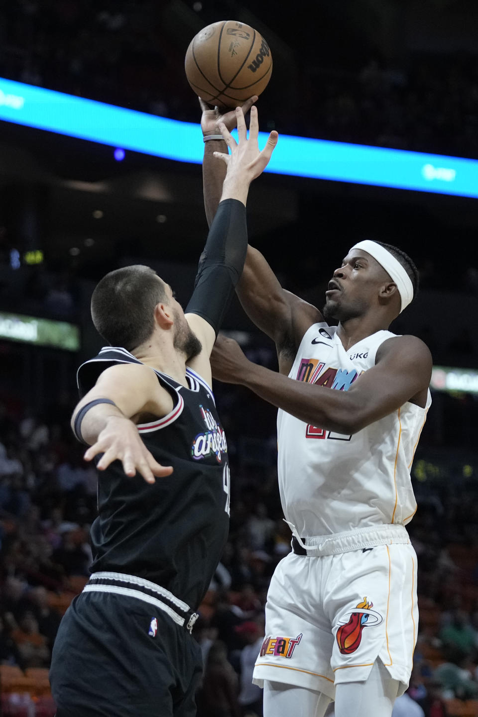 Miami Heat forward Jimmy Butler, right, takes a shot against Los Angeles Clippers center Ivica Zubac during the first half of an NBA basketball game Thursday, Dec. 8, 2022, in Miami. (AP Photo/Wilfredo Lee)