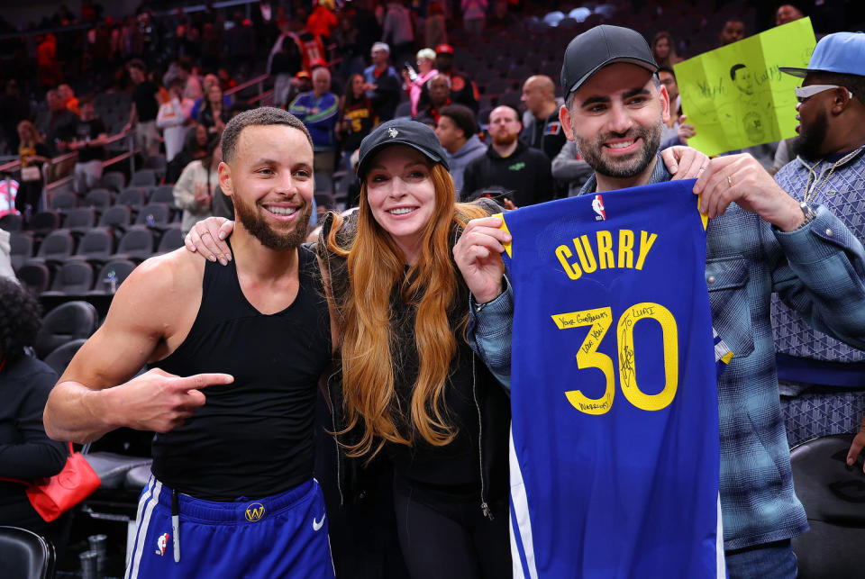 Stephen Curry #30 of the Golden State Warriors poses with actress Lindsay Lohan and her husband Bader Shammas after giving them his jersey in their 141-134 overtime loss to the Atlanta Hawks at State Farm Arena on February 03, 2024 in Atlanta, Georgia. (Kevin C. Cox / Getty Images)