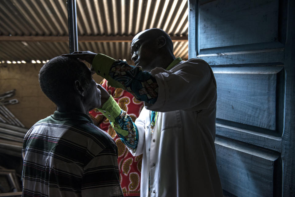 A Congolese doctor checks a patient's eyes. (Photo: Neil Brandvold/DNDi)