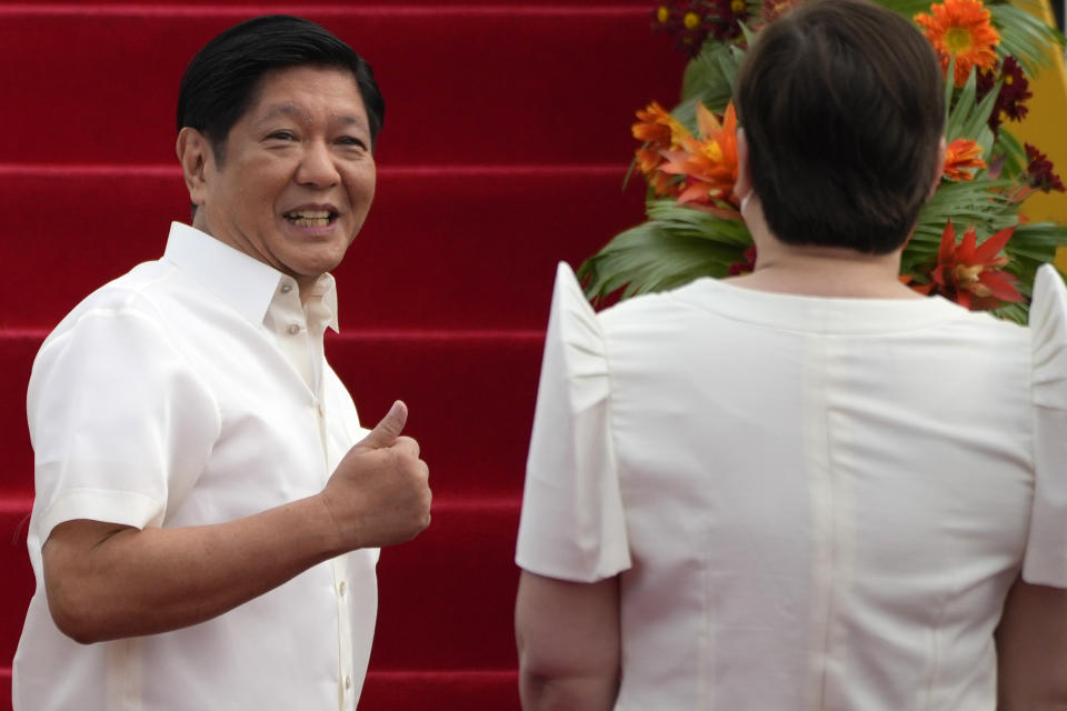 Philippine President Ferdinand Marcos Jr., gestures to Vice-President Sara Duterte as he boards a plane for China on Tuesday, Jan. 3, 2023, at the Villamor Air Base in Manila, Philippines. (AP Photo/Aaron Favila)